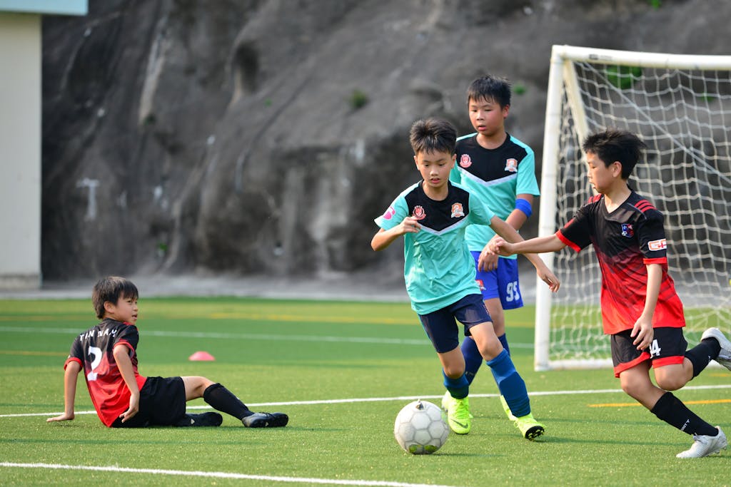 Boys playing a lively soccer match on a sunny soccer field, showcasing teamwork and sportsmanship.