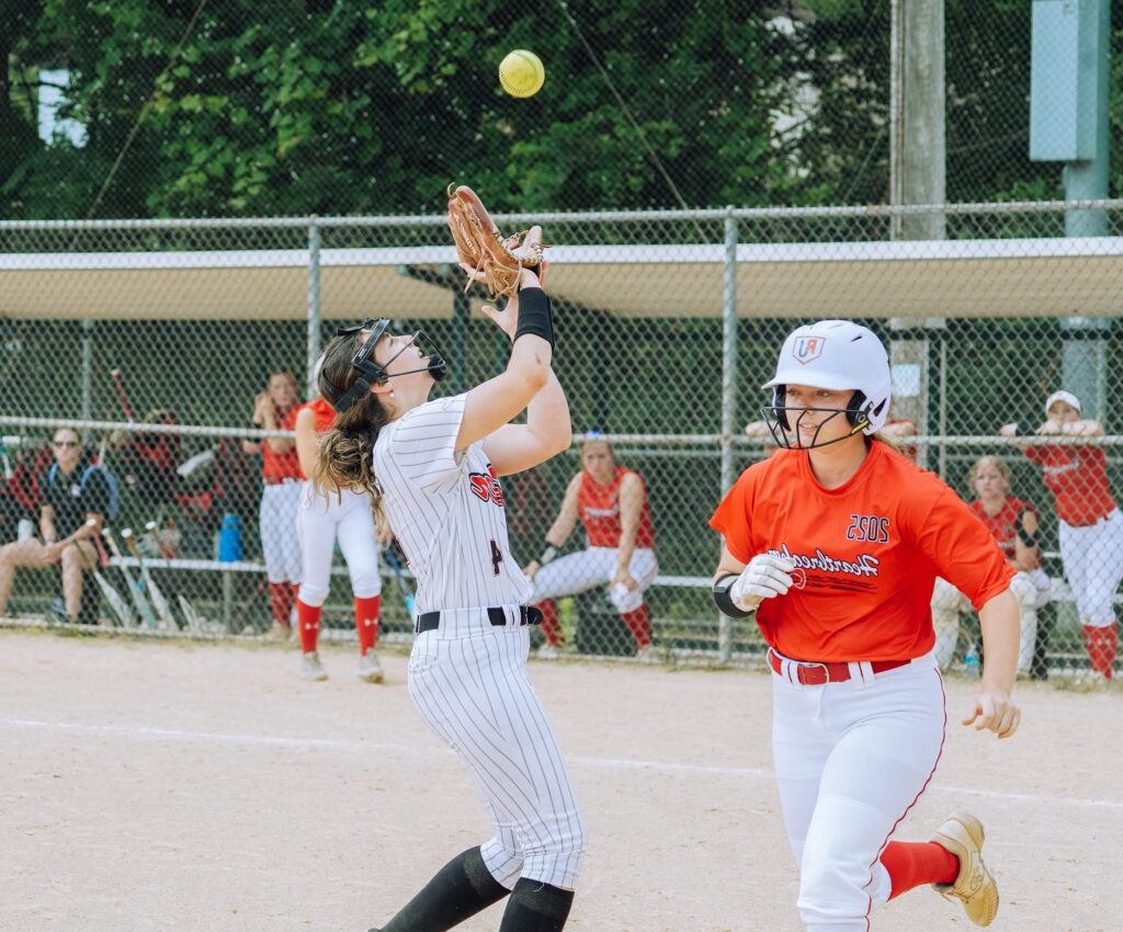 Energetic scene of teenage girls playing softball on a sunny day in Columbia, MD.